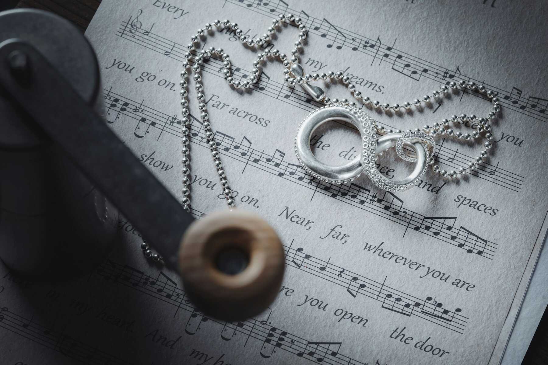 Wedding rings and necklace on sheet music