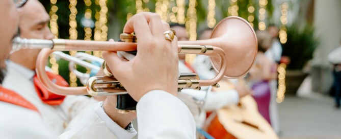 A man in a suit plays a trumpet during a wedding ceremony