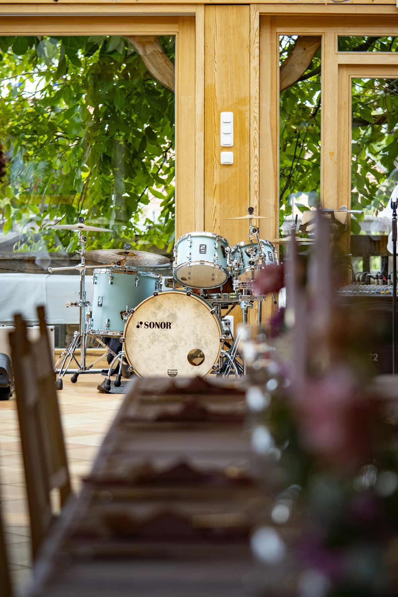 A drumset in front of long table with arrangements
