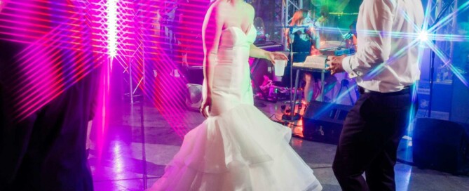 A bride and groom share a joyful dance together at their wedding reception
