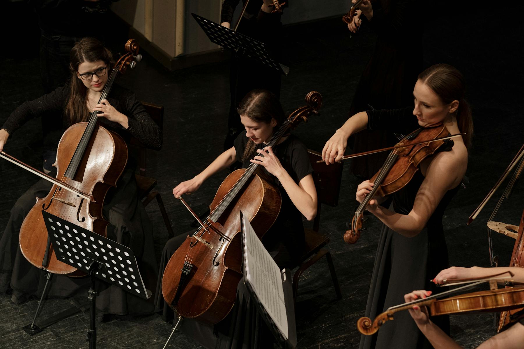 A group of women playing cellos and violins together in a musical performance