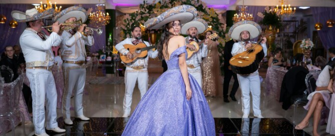 A woman in a purple dress and sombrero stands before a group of musicians