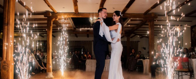 Newlyweds sharing first dance indoors with sparklers