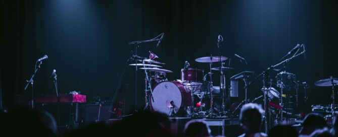Empty concert stage with drum kit and microphones before a show