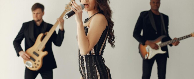 Female singer performing with two guitarists in the background